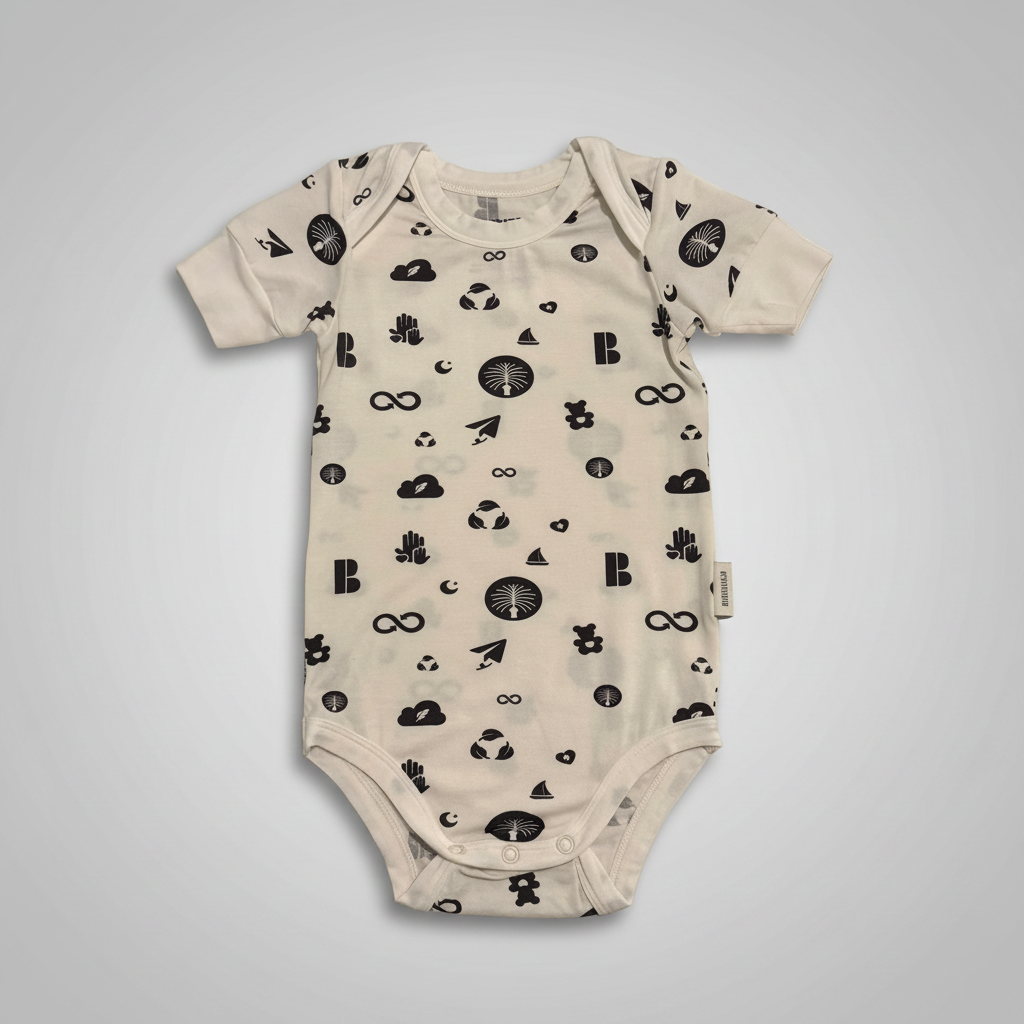 A short-sleeve baby bodysuit in cream with a black all-over print of minimalist icons including trees, clouds, arrows, and symbols, shown flat against a solid gray background.